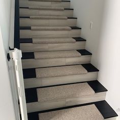 a set of stairs with carpet on the bottom and black treads to the top