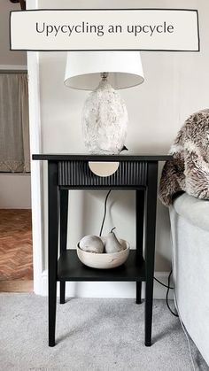 a white lamp sitting on top of a table next to a black and white couch