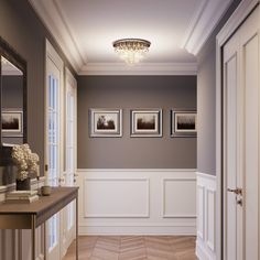 an empty hallway with pictures on the wall and wood flooring in front of it