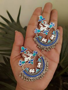 "Add charm and charisma to your beautiful personality with these exquisitely handcrafted Afghani earrings made with high quality German Silver. The intricate design and the glass enamel work renders these earrings a very unique and classy look. Pair them up with any formal or casual attire and gather compliments all the way! Weight 25gm Length 2.8\" Width 1.8\"" Traditional Artistic Design Drop Earrings, Traditional Dangle Jewelry With Artistic Design, Festive Handmade Silver Chandelier Earrings, Unique Silver Danglers For Festive Occasions, Metal Chandbali Danglers With Meenakari, Metal Meenakari Chandbali Danglers, Chandbali Meenakari Danglers In Metal, Meenakari Earrings As Gift, Meenakari Earrings For Gift