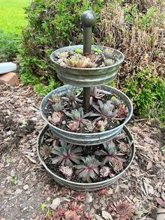 three tiered metal planter with succulents in the middle and one on top