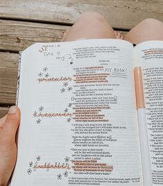 a person holding an open bible with writing on it