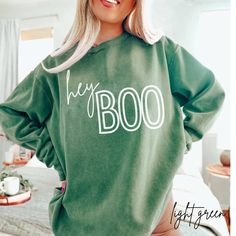 Hey Boo fall sweashirt printed on comfort colors. Perfect sweater for this fall or Halloween season. This sweatshirtis unsisex sizing. For an oversized look, please size up 1-2 sizes.   Luxurious comfort and style are what this unisex, garment-dyed sweatshirt is all about. It's made with 80% ring-spun cotton and 20% polyester and the fabric is 3-end garment-dyed, ring-spun, color-blast fleece with a 100% cotton face. Each sweatshirt comes with a relaxed fit, a rolled-forward shoulder, and a back Halloween Hoodies Cricut, Cricut Fall Sweatshirt Ideas, Fall Hoodie Ideas, Green Sweatshirt With Screen Print For Fall, Green Screen Print Sweatshirt For Fall, Oversized Pre-shrunk Sweatshirt For Fall, Green Halloween Graphic Print Sweatshirt, Oversized Spooky Sweatshirt For Fall, Spooky Cotton Sweatshirt For Fall