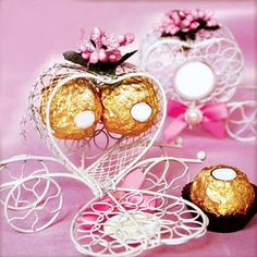 two heart shaped chocolates sitting next to each other on top of a pink table