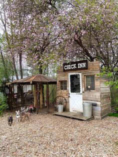 an old fashioned chicken inn with two dogs in the front and one dog on the other side