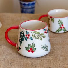 two red and white mugs sitting on top of a table