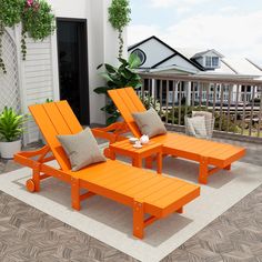 two orange lounge chairs sitting on top of a wooden floor next to a white rug