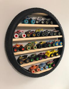 a wall mounted toy car display in a circular black shelf with wooden shelves and wheels