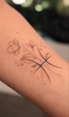 a woman's arm with a cross and flowers tattoo on the back of it