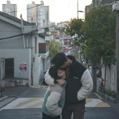 a man and woman kissing on the street