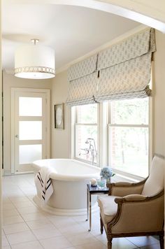 a large bathroom with a tub, sink and toilet in the middle of it's walls