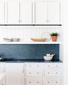 a kitchen with white cabinets and blue counter tops on the instagram page for interior design magazine