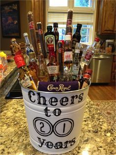 a bucket filled with liquor bottles and condiments sitting on top of a counter