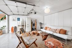 a living room filled with furniture and surfboards