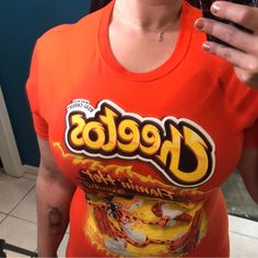 This Is A New Hot Topic Cheetos Shirt Men's Short Sleeve Graphic Tee - Works Well For Ladies Too! Hot Cheetos Graphic New Without Tags Size Small 100% Cotton This Shirt Measures 18" Across The Chest Lying Flat And 27" Long Casual Orange Tops With Graphic Print, Casual Orange Top With Graphic Print, Casual Orange Tops With Screen Print, Orange Relaxed Fit Tops For Streetwear, Orange Letter Print Tops For Streetwear, Orange Graphic Tee With Crew Neck, Orange Graphic Print Top With Relaxed Fit, Fitted Orange Tops With Graphic Print, Orange Graphic Print Tops For Streetwear