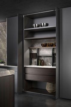 an empty kitchen with stainless steel appliances and marble counter tops, along with dark wood cabinets