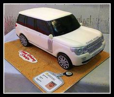 a cake shaped like a white range rover on top of a table with a name tag