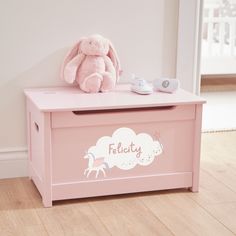 a pink toy chest with a stuffed animal on top and the word feluty written in white