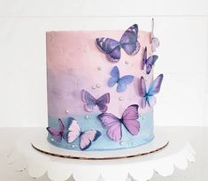 a pink and blue cake with butterflies on it