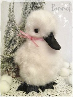 a small white duck with a pink ribbon around its neck