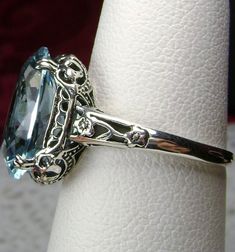 Simulated Aquamarine Ring Edward Design#70 Custom Made Here we have an Edwardian reproduction ring in sterling silver filigree with a perfect Simulated/Man-made blue aquamarine gemstone solitaire. This full cut oval gem is 14mm in length and 10mm in width (slightly smaller gemstone also available upon request). This ring also sits 7mm off the finger. The inside of the band is marked 925 for solid sterling. Notice the beautiful leaf design of the silver filigree setting and etched band. This is a Sky Blue Topaz Ring, Silver Gold Jewelry, Filigree Jewelry, Blue Ring, Aquamarine Ring, Sterling Silver Filigree, Aquamarine Rings, Blue Gems, Silver Art