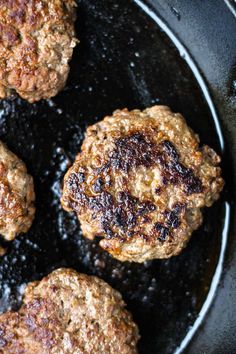 hamburger patties frying in a skillet with oil on the top and bottom