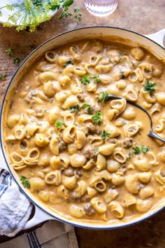 a skillet filled with pasta and meat in gravy, garnished with parsley