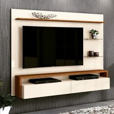 an entertainment center with a flat screen tv mounted on the wall and shelves below it