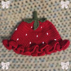 a crocheted strawberry hat with ruffles on it