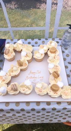 a birthday cake with cupcakes arranged in the shape of letter e