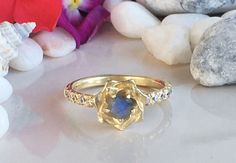 Don't miss this opportunity to own this beautiful gemstone ring crafted in 14k gold filled => Gemstone Type - Labradorite, Clear Quartz => Gemstone Cut - Faceted => Gemstone Size - 4.5 mm, 2 mm => Gemstone Shape - Round Shape => Total Number of Gemstones - 11 => Metal Type - 14k Gold Filled (Tarnish Resistant And Nickel Free) - also available in 925 sterling silver * Please contact me for pricing on a sizes larger than 11 * ~ Feel free to ask me about custom made designs. ❏ Rep Gold Moonstone Ring With Accent Stones For Promise, 14k Gold Flower Shaped Gemstone Jewelry, 14k Gold Gemstone Flower Ring For Anniversary, 14k Gold Flower Ring With Gemstone, Delicate Gold Flower Ring With Gemstone, Unique Yellow Gold Moonstone Ring Gift, Gift Yellow Gold Moonstone Ring With Accent Stones, Yellow Gold Flower-shaped Jewelry With Center Stone, 14k Gold Flower Shaped Gemstone Rings