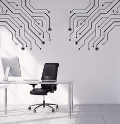 an office desk with a computer on it in front of a circuit board wall decal