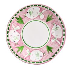 a pink and green plate with white fish on it's rim, in the shape of a circle