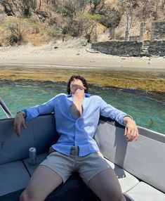 a man sitting on top of a boat in the water