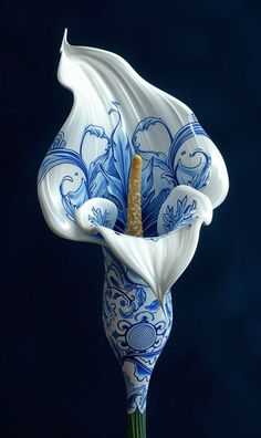 a blue and white vase with flowers on it's side, in front of a dark background