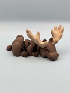 a toy moose laying on its side with it's head up against the ground