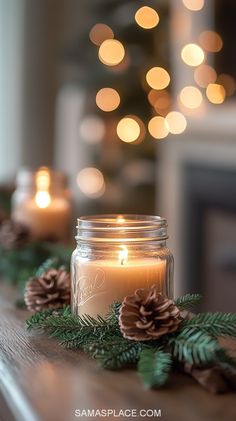 a candle is sitting on a table with pine cones and greenery around it, in front of a lit christmas tree