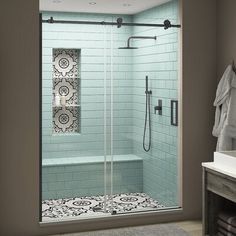 a bathroom with a walk in shower next to a white sink and a gray rug