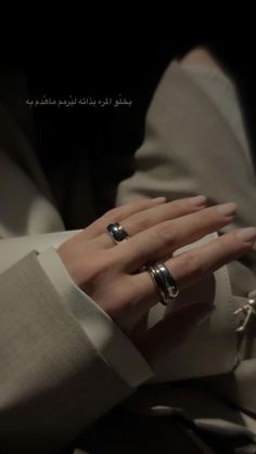 a woman wearing two rings on her hand with the words, i am not sure if she