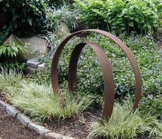 a metal sculpture sitting in the middle of a garden