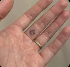 a person's hand with a small tattoo on it