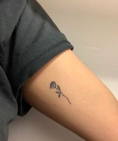 a woman's arm with a small flower tattoo on the left side of her body