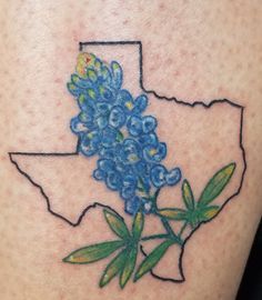 a tattoo with blue flowers in the shape of texas on someone's leg,