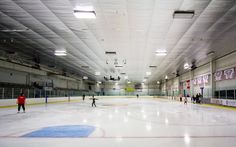 an indoor ice rink with people skating on it