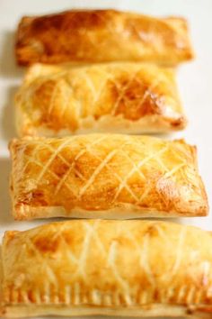 four pastries lined up on a white surface