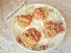 four biscuits on a plate with rice and fruit toppings, sitting on a doily