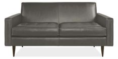 a gray leather couch sitting on top of a white floor