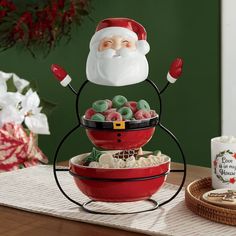 a santa clause sitting on top of two bowls filled with candy and marshmallows