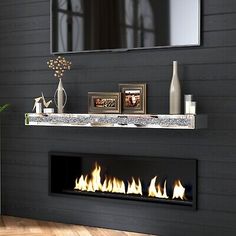 a living room with a fireplace, mirror and vases on the mantle in front of it