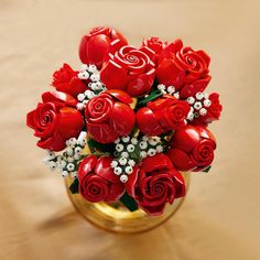 a vase filled with lots of red roses and baby's breath flowers on top of a table